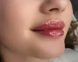 Błyszczące, pełne usta baby doll po zabiegu makijażu permanentnego.