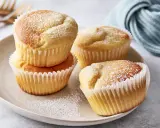 Saftige Quark Muffins, mit Puderzucker bestäubt, auf einem Teller arrangiert. Ein köstlicher Genuss!
