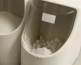 Deux bacs blancs remplis de sel pour adoucisseur d'eau, l'un en poudre, l'autre en pastilles.