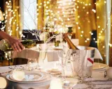 Mesa festiva con luces navideñas, champán y vino. Ideas para decorar un bar para Navidad con estilo y elegancia.