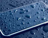 Smartfon pokryty kroplami wody, podkreślający jego wodoodporność IP.