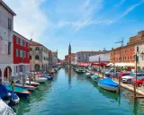 Vue d'un canal à Chioggia, Venise, avec des bateaux amarrés le long des maisons colorées.