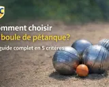 Guide complet pour comment choisir ses boules de pétanque. Des boules métalliques et une petite boule orange sur un terrain de sable.