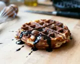 Gaufre au chocolat dégoulinant, saupoudrée de cacao. Un délice gourmand prêt à être dégusté.