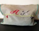 Uszyta ręcznie kosmetyczka z inicjałami "A" i "K" wyszytymi haftem krzyżykowym.