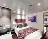 Cabina MSC Grandiosa ponte 8: letto matrimoniale, quadro con medusa, specchio e arredi moderni.