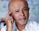 Ritratto di Abraham Verghese, con la mano sulla tempia, pensieroso.