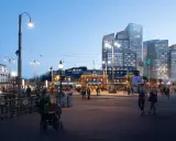 Kvällsliv vid Centralstationen i Göteborgs stadskärna. En spårvagn stannar medan folk promenerar förbi moderna skyskrapor.