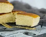 Un trozo de sobada riojana, esponjosa y dorada, descansa sobre una rejilla junto a un tenedor.