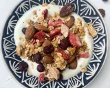 Schüssel mit Joghurt, garniert mit knusprigem Müsli, Mandeln, gefriergetrockneten Erdbeeren und Blaubeeren. Perfekt für gesunde Frühstücks-Granola-Rezepte.