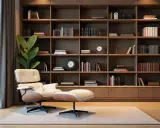 Un fauteuil confortable et un pouf invitent à la lecture dans ce salon où l'on a choisi d'aménager une bibliothèque murale.