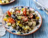 Salade colorée de lentilles vertes avec tomates, concombre, olives noires et feta. Un plat frais et savoureux.