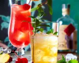 Zwei erfrischende Cocktails, einer rot, der andere gelb, mit Minze und Früchten. Ein **Cocktail mit Bier**-Mix? Vielleicht.