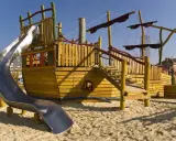 Parque infantil con barco de madera y tobogán, ideal para la vitoria con niños. ¡Aventuras piratas garantizadas!