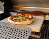 Pizza auf Pizzastein im Backofen, bereit zum Servieren. Eine Anleitung für den perfekten Pizzagenuss.