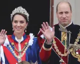 Kate Middleton och Prins William, medlemmar av brittiska kungahuset, vinkar från en balkong i sina högtidliga dräkter och juveler.