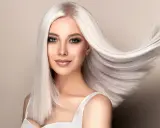 Kobieta z olśniewającymi, długimi włosami w odcieniu perłowy blond, które falują na wietrze.
