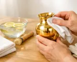 Nettoyer métal doré oxydé avec une solution de citron et de l'eau. Un petit vase brille après le nettoyage.