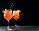 Zwei Aperol Spritz Gläser mit Orangenscheibe und Zitrusschale, perfekt für das Aperol Spritz Rezept in ml.