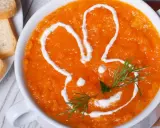 Pomarańczowa marchwianka z ryżem na biegunkę, ozdobiona śmietaną w kształcie królika. Podana z grzankami.