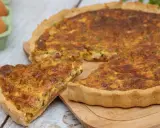 Une part de quiche lorraine dorée, avec sa garniture aux lardons et herbes, prête à être dégustée. La vraie recette quiche lorraine.