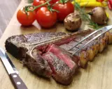 Una succulenta bistecca alla fiorentina, tagliata e pronta per essere gustata. Perfetta per scoprire dove mangiare la fiorentina a Firenze.