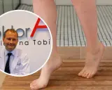 Lekarz w białym kitlu obok stóp z uczuciem ciężkich nóg. Woda na skórze sugeruje problem z krążeniem.