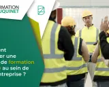 Un formateur explique les consignes de sécurité à une équipe en tenue de travail. Une formation sécurité en entreprise est essentielle.
