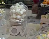 Mesa dulce con palomitas, merengues, cupcakes y letras de madera "LOVE".