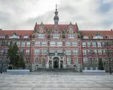 Imponujący budynek Politechniki Gdańskiej, jednej z ważnych uczelni Gdańsk, z charakterystyczną wieżą zegarową i ozdobną fasadą.