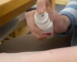 Dłoń trzymająca spray z oktenidyną, gotowa do dezynfekcji skóry.