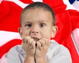 Przerażony chłopiec przed flagą Wielkiej Brytanii. Czy tak wygląda nauka jak nauczyć się mówić po angielsku?