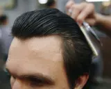 Profesjonalny styling włosów: grzebień i nożyczki w akcji, tworząc idealną fryzurę.
