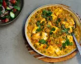 Cremiges Matar Paneer mit Erbsen und würzigen Paneer-Würfeln, garniert mit Koriander. Daneben ein frischer Salat.