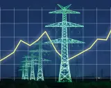 Strommasten im Abendlicht, überlagert von einem steigenden Graphen. Ein Symbol für die Energiewende in Deutschland und den Ausbau erneuerbarer Energien.