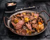 Joue de bœuf effilochée, tendre et savoureuse, servie avec des légumes fondants. Un délice pour les amateurs de viande.