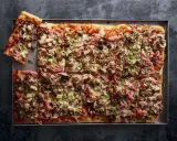 Domowa pizza na blachę z szynką, pieczarkami i oliwkami. Idealna na rodzinne spotkanie, łatwy przepis.