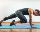 Kobieta wykonuje ćwiczenie w stylu hiit, co to za trening? Dynamiczne ruchy na macie.