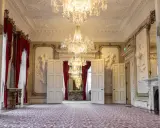 Ett elegant rum med kristallkronor och röda draperier i Dicksonska palatset.