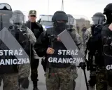 Funkcjonariusze Straży Granicznej w pełnym rynsztunku, z tarczami, gotowi do akcji. Ich praca w straży granicznej to zapewnienie bezpieczeństwa.