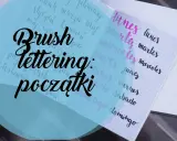 Pismo kaligraficzne "Brush Lettering: początki" na kratkowanym zeszycie, obok dni tygodnia po hiszpańsku.