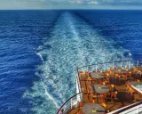 Scia di un'imbarcazione Costa Crociere, con tavoli e sedie arancioni sul ponte, ideale per escursioni libere in mare aperto.