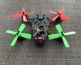 Ein kleiner, bunter Quadrocopter mit roten und grünen Propellern, bereit für aufregendes FPV fliegen.