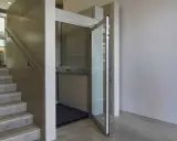 Una piattaforma elevatrice accanto a una scala, una soluzione per chi cerca come abbassare i gradini di una scala, rendendo l'accesso più agevole.