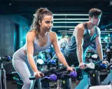 Para ćwiczy cardio na rowerze w siłowni.