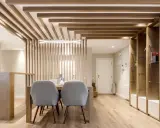 Comedor moderno con separador de listones de madera y estanterías. Preguntarse cuanto se tarda en tirar un tabique es irrelevante aquí.