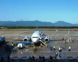 Flugzeug am **Girona Flughafen** mit Passagieren, die einsteigen. Berge im Hintergrund.