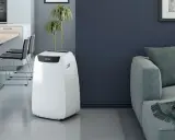 Un climatiseur Electrolux blanc, discret et moderne, se tient dans un salon épuré, prêt à rafraîchir l'espace.