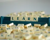 Litery na kafelkach układają się w słowo LEARN, symbolizując naukę i rozwijanie słownictwa. To świetny przykład na word formation C1.