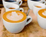 Kaffee-Kunst: Ein Cortado und ein Flat White, die sich in ihrer Zubereitung unterscheiden, aber beide mit Latte Art verziert sind.